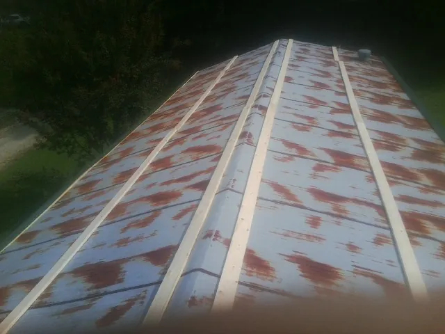 Rusted metal roof panels with new wood purlins before replacement — Storm Damage Roof Repair in Rebuck by Roofing Brothers