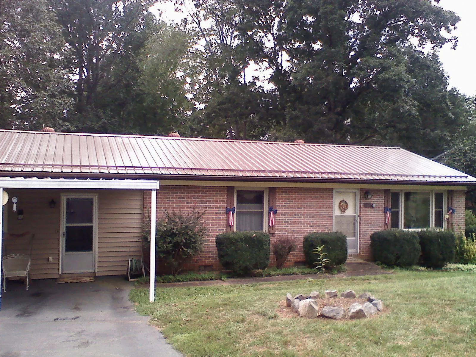 Bronze metal roof and carport on a brick ranch home — Roof Repair work by our crew in Rebuck